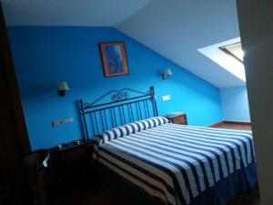 a bedroom with a bed with a blue wall at Pension Arenas in Ajo