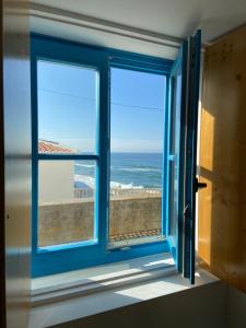 an open window with a view of the ocean at Azenhas do Mar West Coast Design and Surf Villas in Sintra