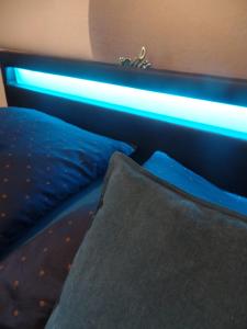 a bedroom with a bed with a blue light at Apartmány City in Ostrava