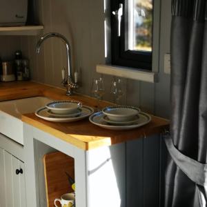 a kitchen counter with two plates and a sink at Pen-Rhos luxury glamping "Cuckoo's Nest" in Llandrindod Wells