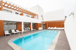 a pool at a hotel with chairs and tables at Hotel Da Luz in Santa Maria