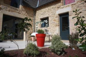 a large red pot sitting in front of a building at Domaine de la Prévostais in Pleucadeuc +10 photos