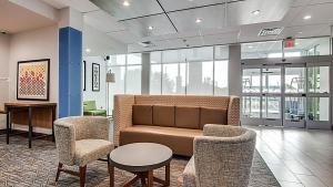 a lobby with a couch and two chairs and a table at Holiday Inn Express Hotel & Suites Mount Pleasant, an IHG Hotel in Mount Pleasant