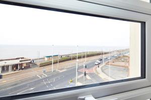 uma janela com vista para uma estrada com carros em Queens Mansions: Lakeland Suite em Blackpool