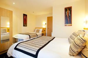 um quarto de hotel com duas camas com almofadas em Queens Mansions: Lakeland Suite em Blackpool