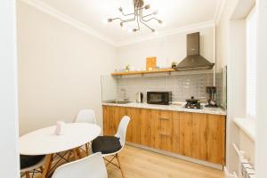 a kitchen with a white table and chairs and a white table at Avangard Aparts - Avangard in Atyraū