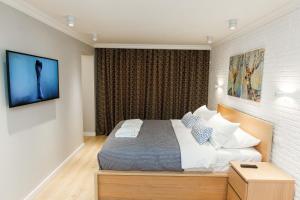 ein Schlafzimmer mit einem Bett und einem TV an der Wand in der Unterkunft Avangard Aparts - Avangard in Atyrau