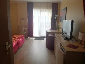 a hotel room with a bed and a television in it at Pension Fürst Borwin in Markgrafenheide