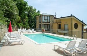 a swimming pool with chairs and a house at Residence Montefiore in San Baronto