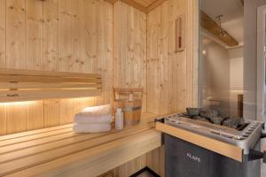 a sauna with wooden walls and a sink and towels at Herzbergs.Ferienwohnungen Meerfühlen in Scharbeutz