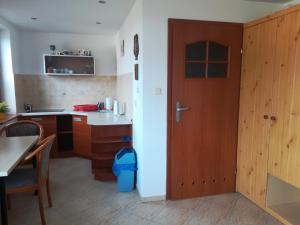 a kitchen with a wooden door and a table at Apartament Super Karpacz in Karpacz