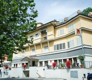 un hotel con flores rojas delante de él en Residence Montefiore, en San Baronto
