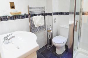 a bathroom with a toilet and a sink and a shower at Queens Mansions: Ocean View Apartment in Blackpool