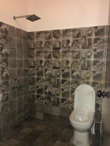 a bathroom with a white toilet in a room at Lemon Dew Beach House, Alleppey Beach in Alleppey