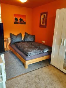 łóżko w pokoju z pomarańczową ścianą w obiekcie Monteurswohnung Monteurunterkunft w mieście Heilbronn