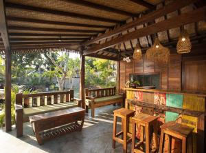 a patio with benches and tables and a kitchen at Green Space Villa in Ubud