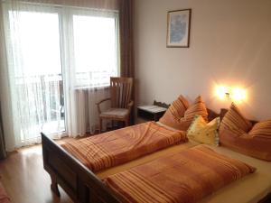 1 dormitorio con 2 camas y 1 silla en Alpengasthaus Sonnhof en Goding