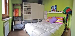 1 dormitorio con cama blanca y pared verde en Apartamentos Sabor Rural II, en León