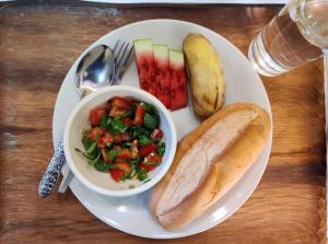 um prato de comida com uma tigela de salada e uma sanduíche em Bike&Bed em Thakhek