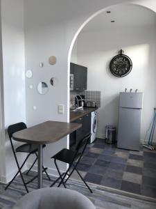 uma cozinha com uma mesa e cadeiras e um frigorífico em charmant studio Pont-Audemer em Pont-Audemer