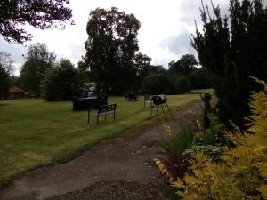 park z ławkami i grillem w trawie w obiekcie Liahof w mieście Ullared