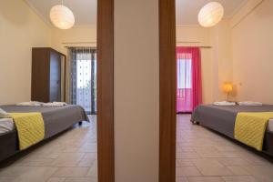 a room with two beds and two windows at Villa Katerina in Siviri +215 photos