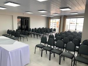 a room with rows of chairs and a white table at AH Hotel in Santa Cruz de la Sierra