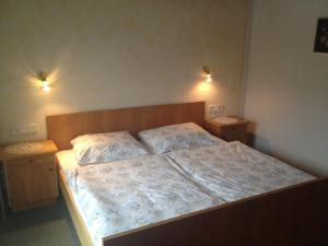 1 dormitorio con 1 cama grande y 2 mesitas de noche en Gästehaus Lisbeth, en Bad Kleinkirchheim