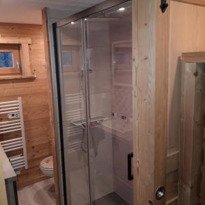 uma cabina de duche em vidro numa casa de banho com banheira em Le Valmandine em La Bresse