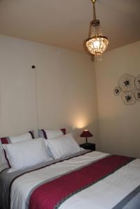 una camera con due letti e un lampadario a braccio di Le Mas de Lucas a Arles