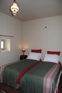 una camera da letto con un grande letto con una coperta verde di Le Mas de Lucas a Arles