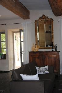 a living room with a couch and a mirror at Le Mas de Lucas in Arles