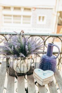 a bench with a blue vase and flowers on it at Dona Fina Guest House in Mirandela