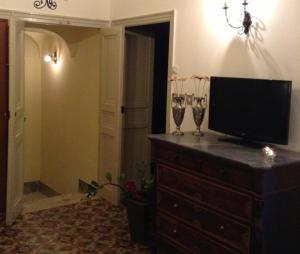 カステッランマーレ・デル・ゴルフォにあるVerdi Apartmentのワイングラス2杯付きドレッサーのテレビ1台
