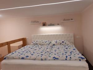 Adél Apartman في كابوسفار: غرفة نوم بسرير ابيض وملاءات ووسائد زرقاء