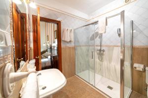 a bathroom with a glass shower and a sink at Alvar Fañez in Úbeda