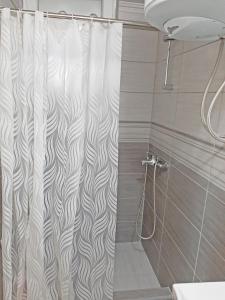 y baño con ducha con cortina blanca. en Apartment Aurora en Foča