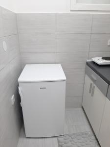 una nevera blanca en un baño con encimera en Apartment Aurora en Foča