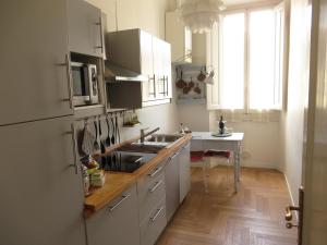 eine Küche mit weißen Schränken, einer Spüle und einem Tisch in der Unterkunft Dimora senza tempo in Florenz