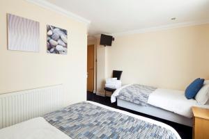 a hotel room with two beds and a television at Queens Mansions: Hesketh Apartment in Blackpool