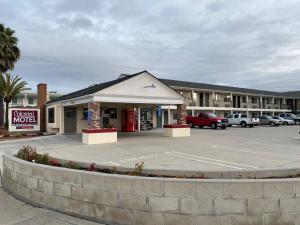 a small motel with a parking lot in front of it at Colonial Motel in Santa Maria