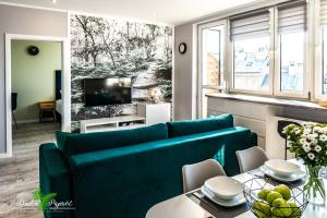 ein Wohnzimmer mit einem blauen Sofa und einem Tisch in der Unterkunft Apartament Dzika Paproć in Szczawnica