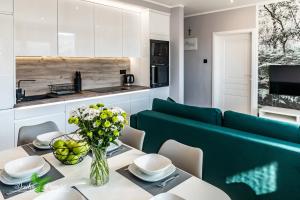 a living room with a table and a green couch at Apartament Dzika Paproć in Szczawnica
