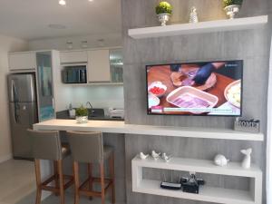 ボンビーニャスにあるMariscal 02 dormitórios, 80m do mar, com piscinaのキッチン(壁に薄型テレビ付) +16枚の写真