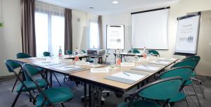 uma sala de conferências com uma mesa longa e cadeiras em Campanile Lille Sud - CHR em Lille