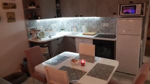 een keuken met een tafel en een witte koelkast bij Kuća za odmor Jelena in Starigrad-Paklenica