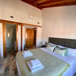 1 dormitorio con 1 cama grande y 2 toallas. en Apartamentos Ejemplares, en Alcalá de Henares