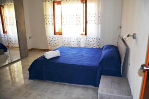 niebieskie łóżko w pokoju z oknem w obiekcie B&b Aloysia w mieście Iglesias
