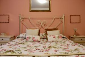 a bedroom with a bed with a floral bedspread at VUCCIRIA 57 locazione turistica nel cuore pulsante della movida! in Palermo