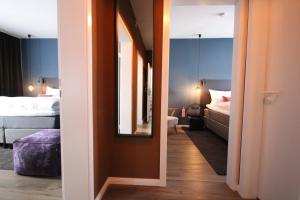 Zimmer mit einem Bett und einem Spiegel sowie einem Schlafzimmer. in der Unterkunft ONNO Boutique Hotel & Apartments in Rendsburg